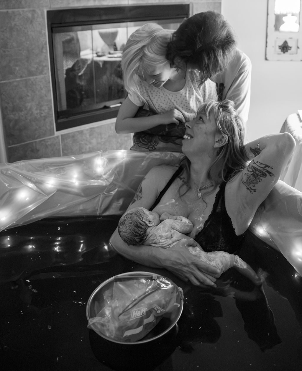 Black and white home birth photography in Las Vegas — big sister meeting the new baby