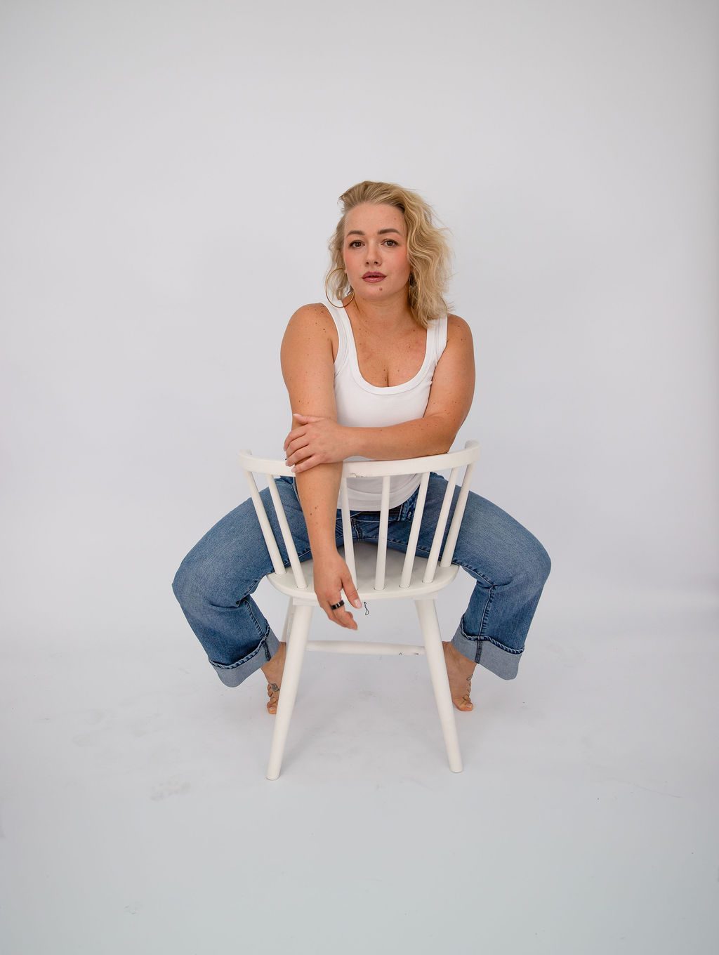 Studio portrait photography in Las Vegas — woman seated on a white chair