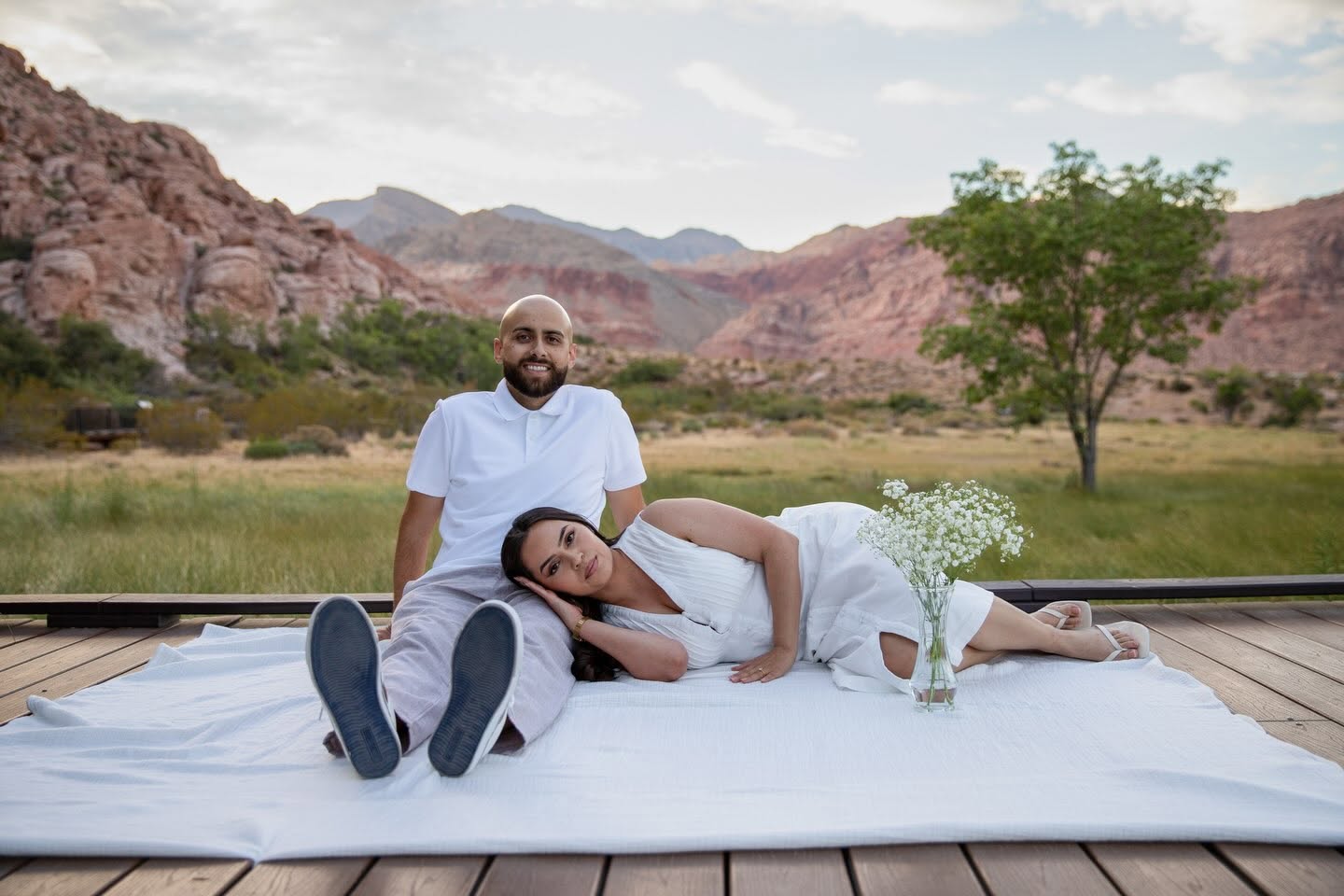 Couple resting on a picnic blanket in the desert
