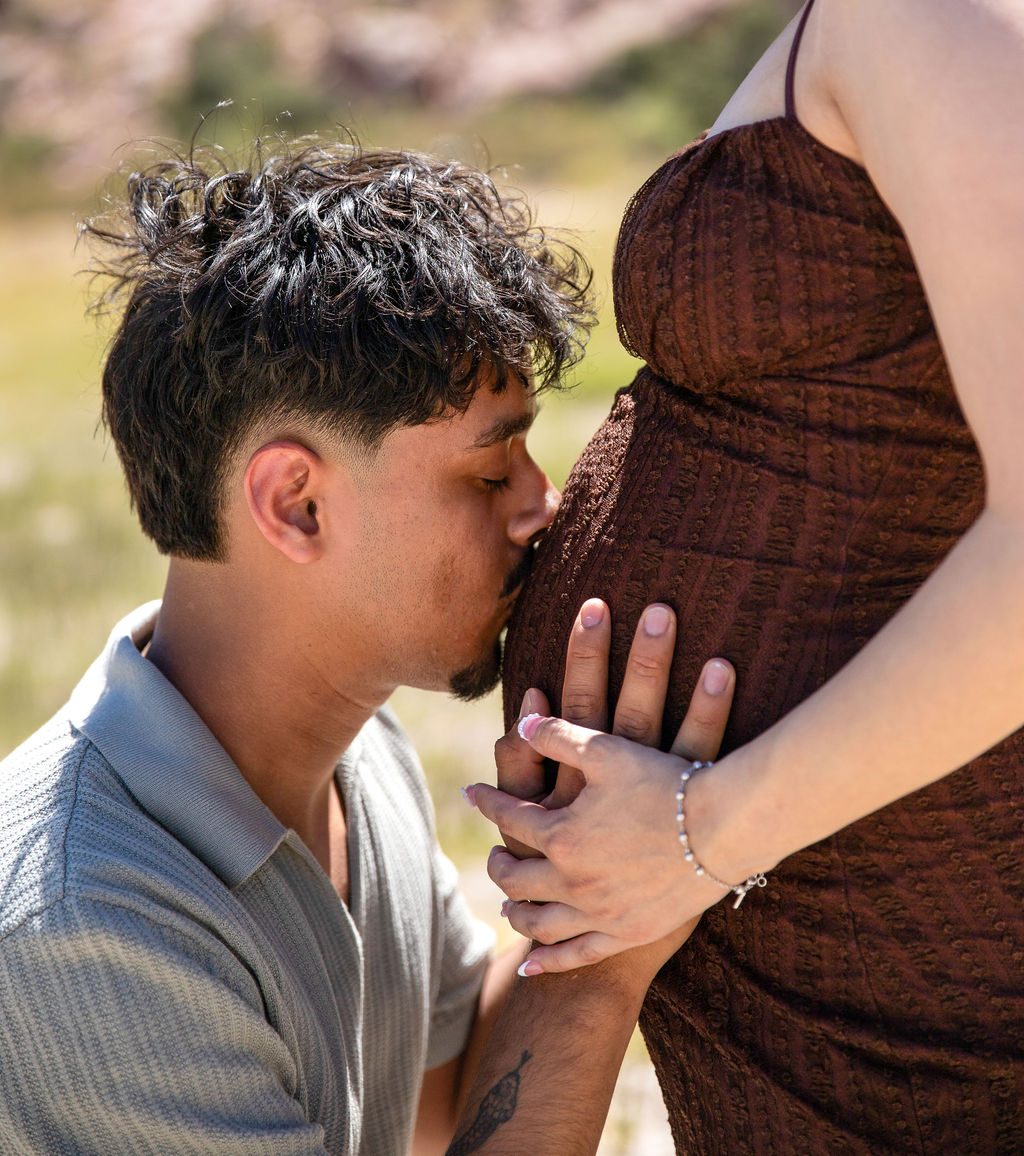Maternity photography in Las Vegas — father kissing his partner’s bump
