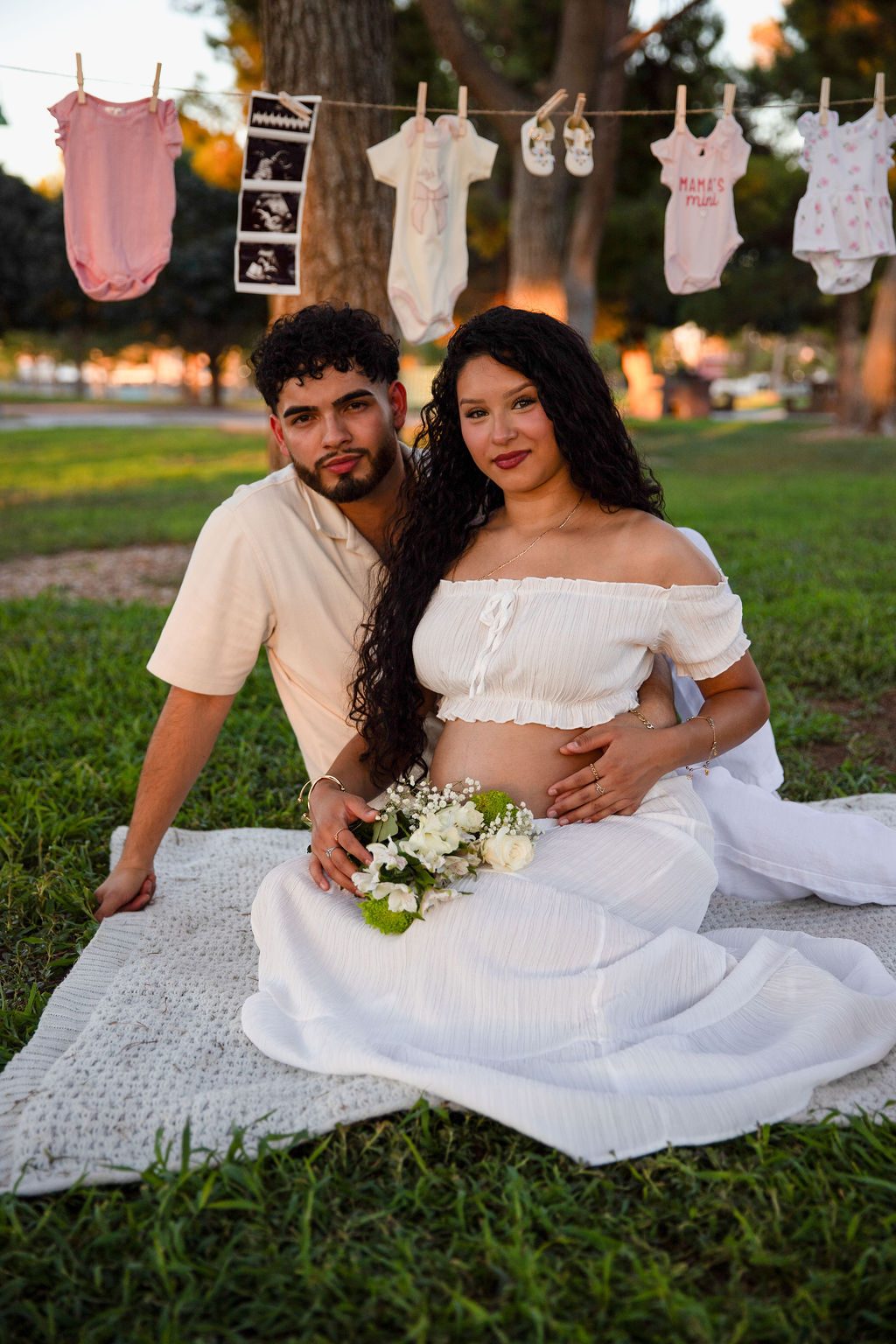 Maternity photography in Las Vegas — couple in a park at sunset with baby clothes strung above them