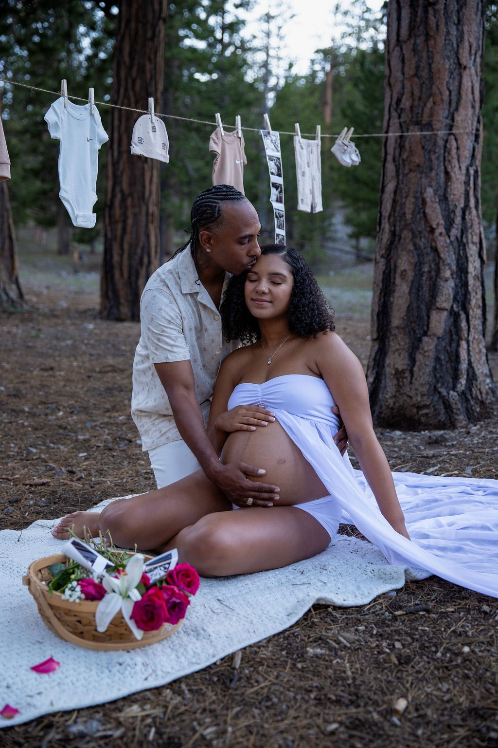 Maternity photography in Mount Charleston near Las Vegas — couple among the pines with baby clothes on a line