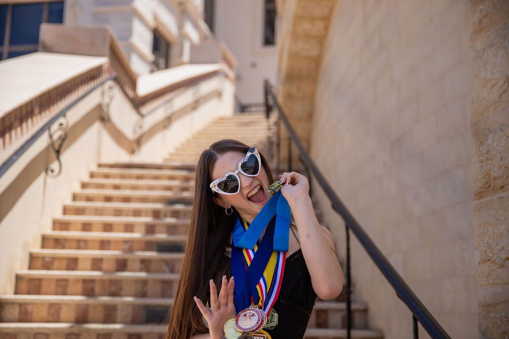 Senior photography in Las Vegas — graduate laughing with her academic medals